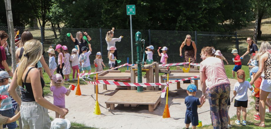 Kinder und Erwachsene am Wasserspielplatz vor der Eröffnung